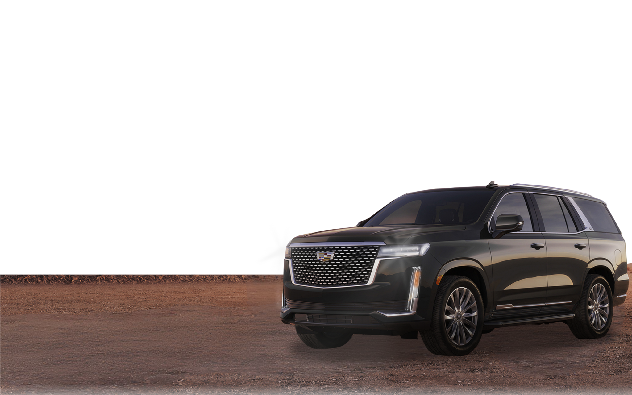 Grafitowy Cadillac Escalade zaparkowany na pustynnej drodze o zachodzie słońca