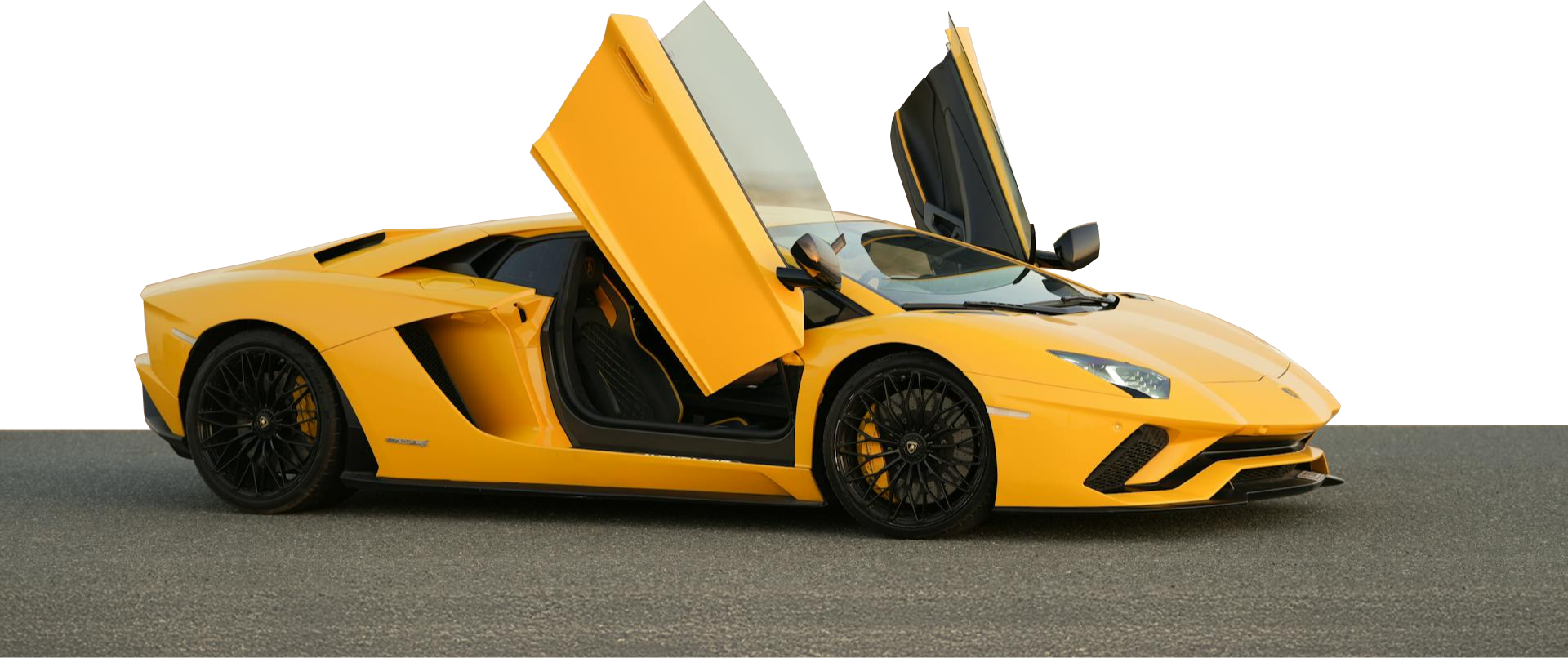 Żółte Lamborghini Aventador z uniesionymi drzwiami nożycowymi stoi bokiem na drodze