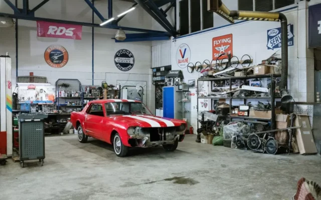 Czerwony klasyczny Ford Mustang w warsztacie podczas renowacji nadwozia i przodu auta
