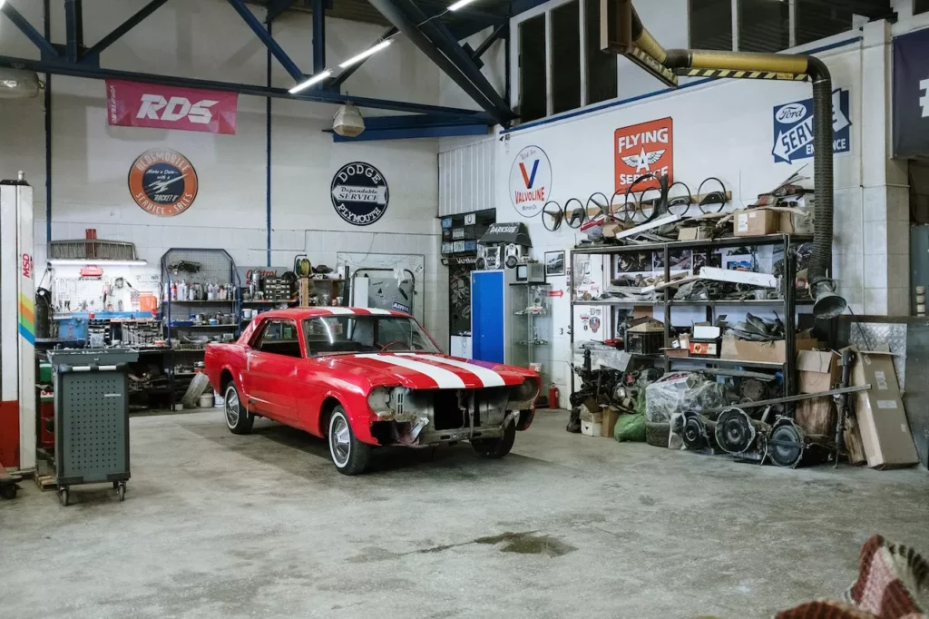 Czerwony klasyczny Ford Mustang w warsztacie podczas renowacji nadwozia i przodu auta