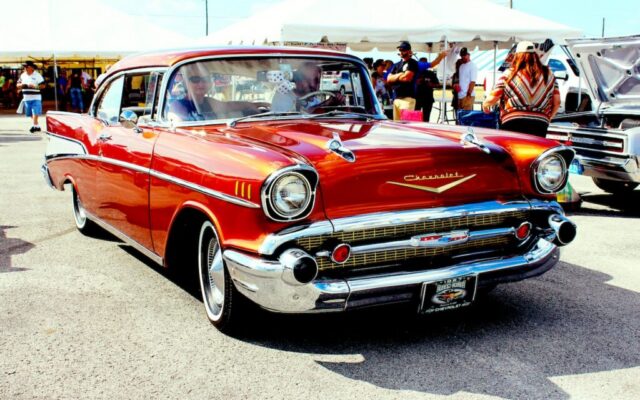 Czerwony klasyczny Chevrolet Bel Air na zlocie samochodowym, prezentowany przed namiotami