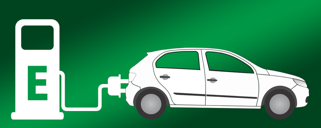 Samochód elektryczny podłączony do stacji ładowania na zielonym tle