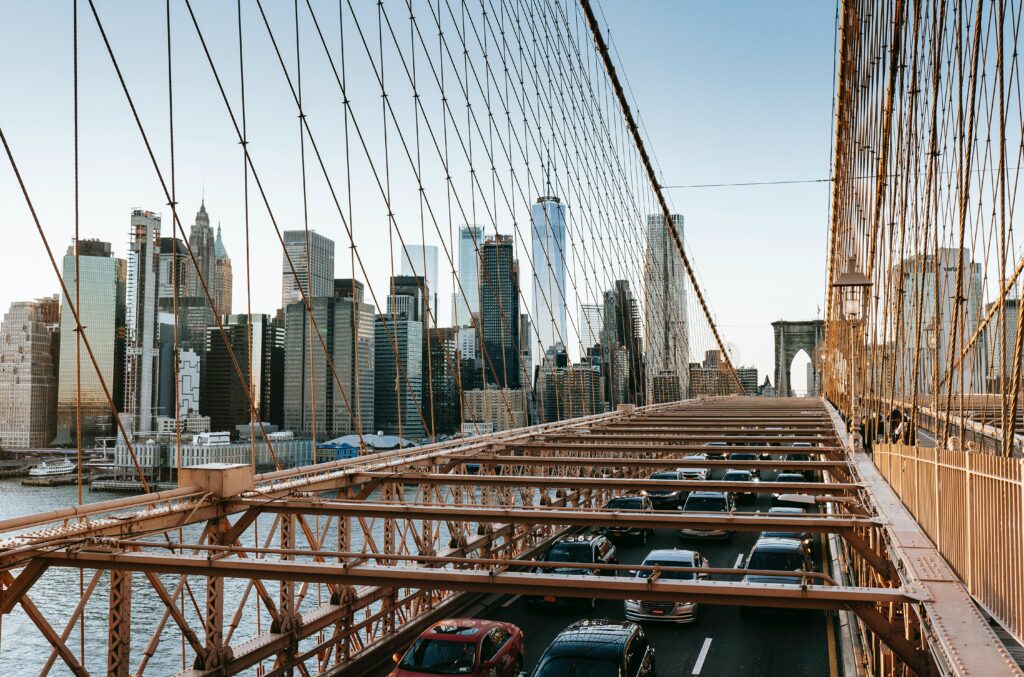 Most Brookliński z ruchem samochodowym i panoramą Manhattanu nad East River