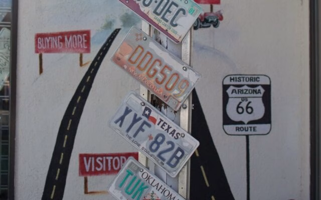 Tablice rejestracyjne USA na słupie przy muralu Route 66 w Arizonie