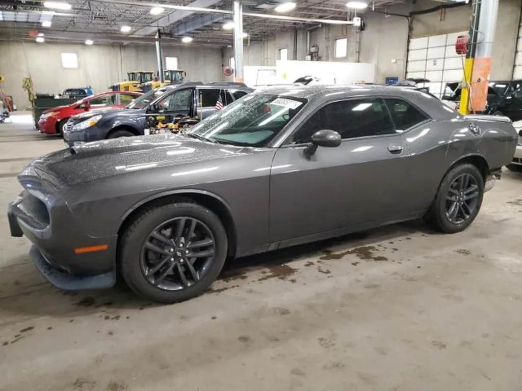 Szary Dodge Challenger coupe stojący w hali serwisowej, widok z boku.