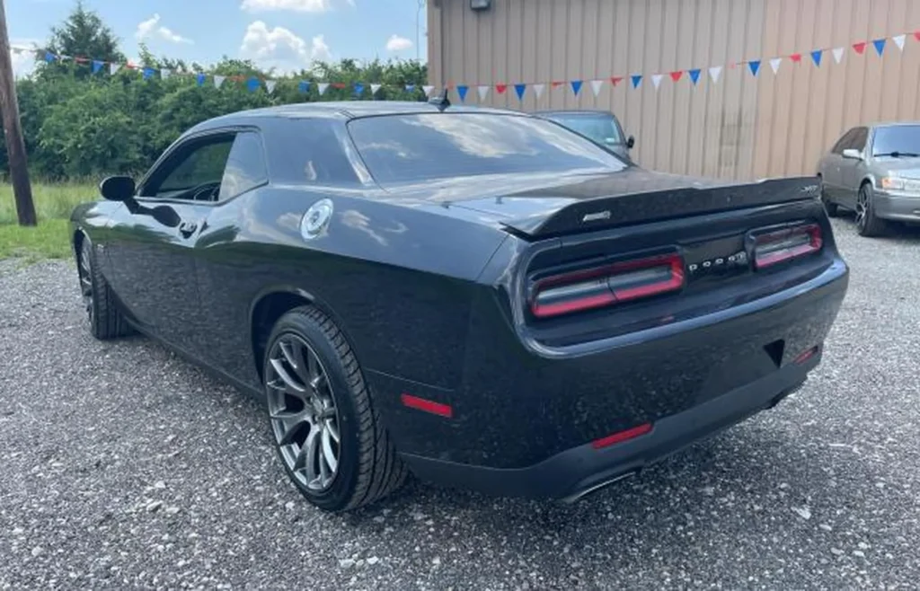 Tył Dodge Challenger - ujęcie 3/4 z prawej, szeroki spoiler, poziome lampy LED, emblemat SRT, sportowe koła.