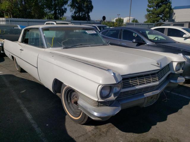 Biały klasyczny Cadillac coupe, zmatowiały lakier, auto w stanie do renowacji na parkingu.