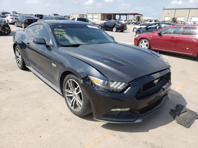 Czarny Mustang GT, przód-lewy rzut, lekkie uszkodzenia zderzaka i maski.