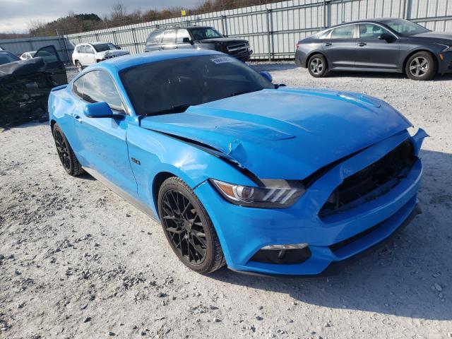 Niebieski Mustang GT z przodu z lewej, uszkodzony i podniesiona maska, brak grilla.