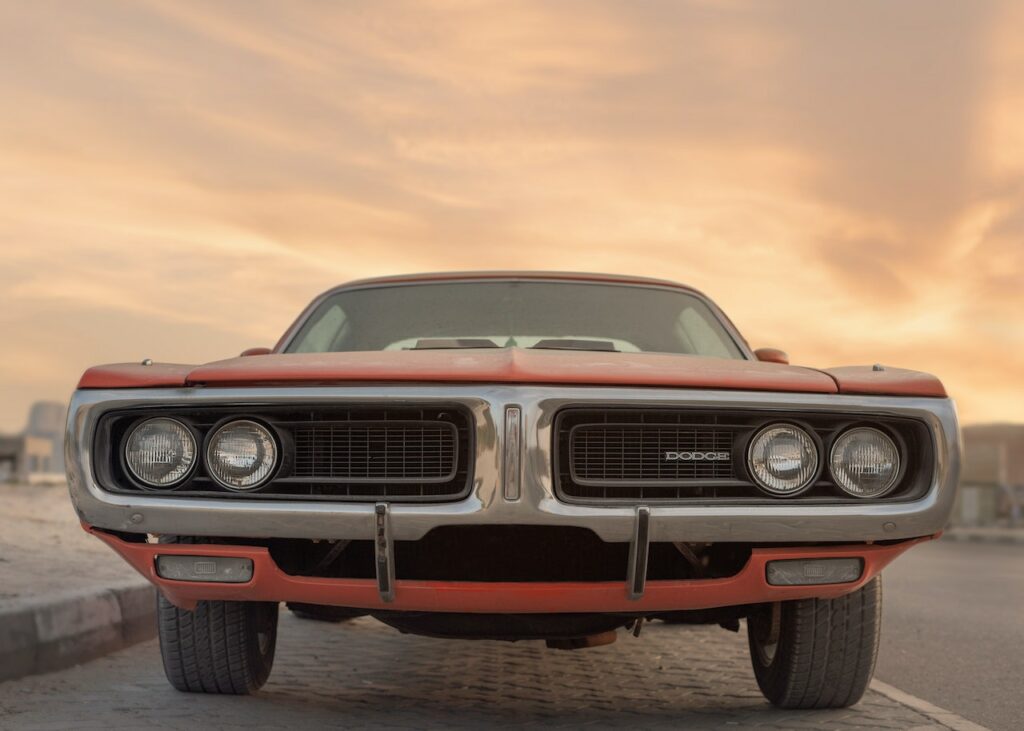 Klasyczny Dodge Charger z przodu na pustej drodze o zachodzie słońca
