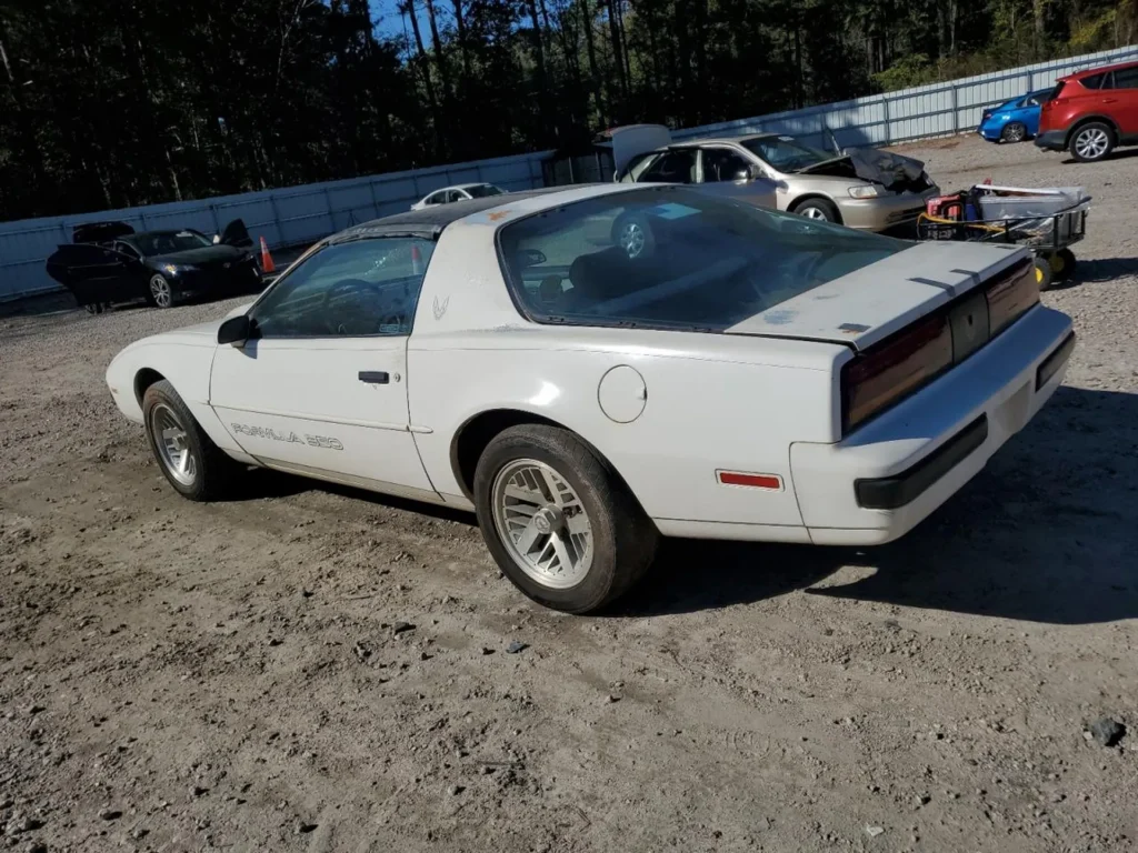 Tylny lewy róg Pontiaca Firebird Formula 350 - profil auta na żwirze, stan do renowacji.