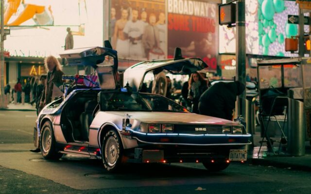 DeLorean z Powrotu do przyszłości z otwartymi drzwiami stoi nocą na Times Square