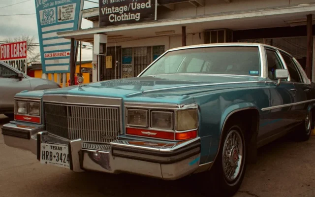 Niebieski zabytkowy Cadillac zaparkowany przed sklepem z odzieżą vintage w Teksasie