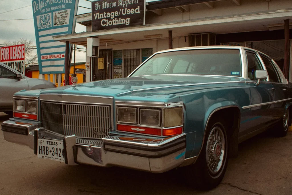 Niebieski zabytkowy Cadillac zaparkowany przed sklepem z odzieżą vintage w Teksasie