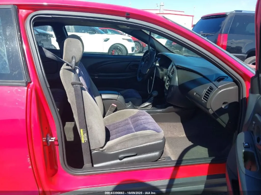 Wnętrze Chevrolet Monte Carlo – fotel kierowcy i deska rozdzielcza; tapicerka materiałowa, manualna regulacja fotela.