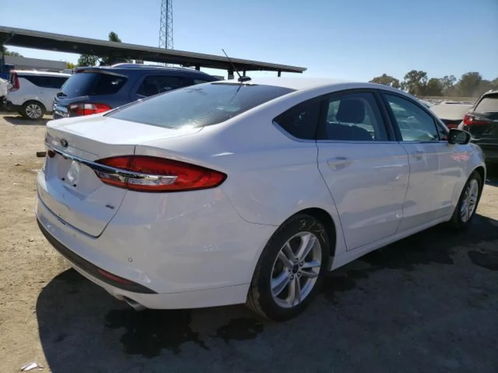 Biały Ford Fusion – tylno-prawy róg, linia fastback, felgi aluminiowe 5-ramienne.
