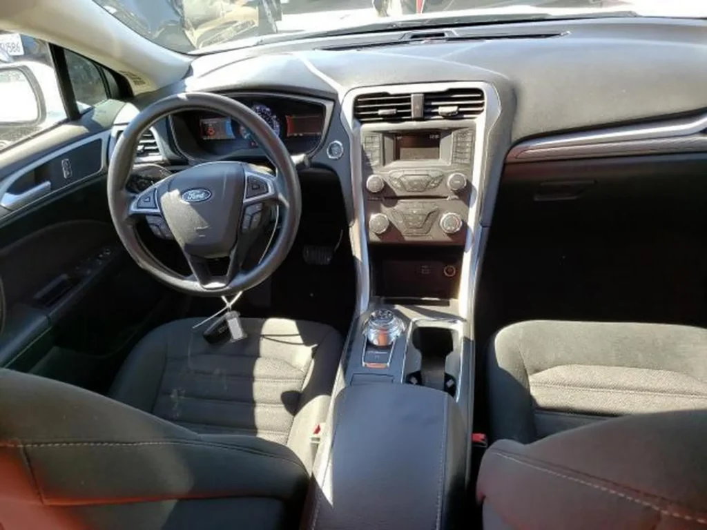 Wnętrze Ford Fusion – kokpit i fotele materiałowe, kierownica wielofunkcyjna, pokrętło skrzyni biegów.