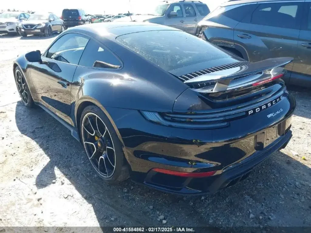 Tył i prawa strona Porsche 911 Turbo S - widoczny aktywny spojler, dwie pary końcówek wydechu, lakier czarny.