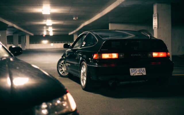 Czarna Honda CRX z włączonymi tylnymi światłami w podziemnym parkingu nocą