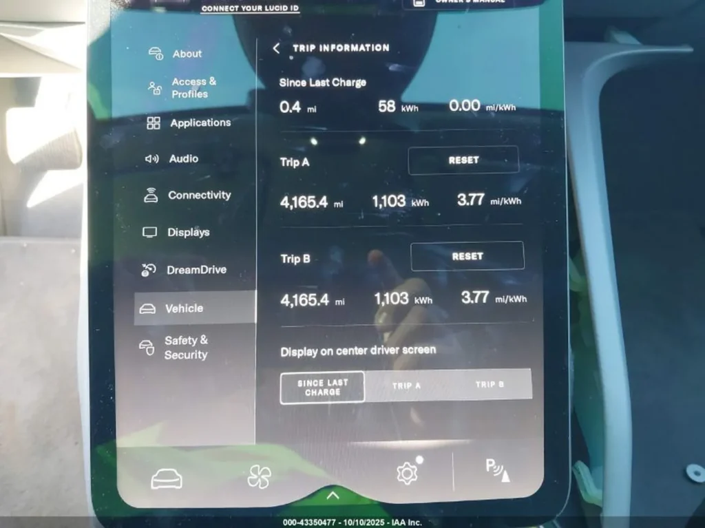 Zbliżenie centralnego ekranu Lucid Air z menu i danymi podróży.