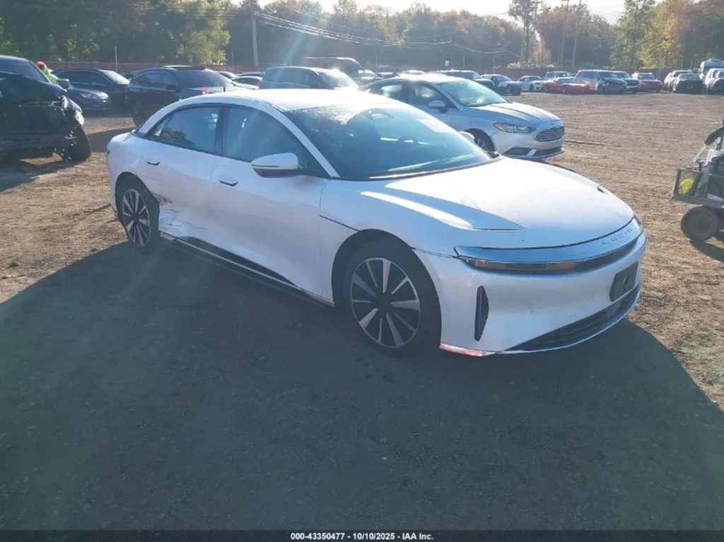 Biały Lucid Air, przód-lewy rzut, wgniecenia lewych drzwi i progu.