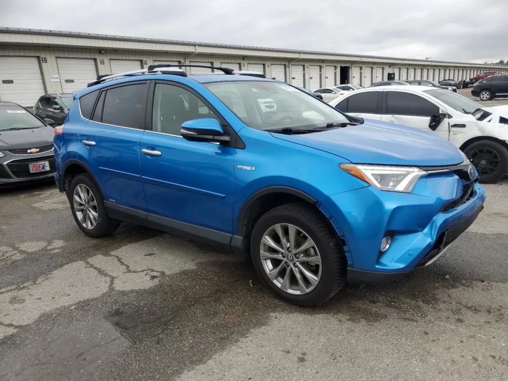 Niebieska Toyota RAV4 Hybrid, ujęcie z prawego przodu; uszkodzony zderzak i brak dolnej listwy, tło magazynowe.