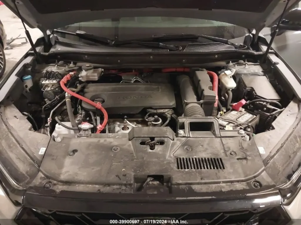 Komora silnika hybrydy Honda CR-V z pomarańczowymi przewodami wysokiego napięcia.