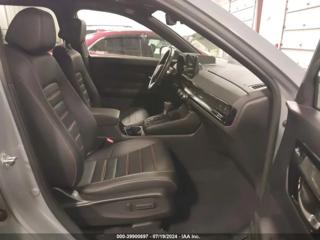 Wnętrze Honda CR-V: czarne fotele z pomarańczowymi przeszyciami, kokpit.
