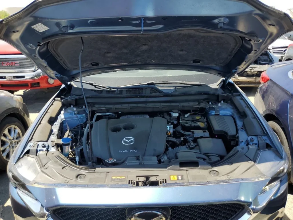 Komora silnika Mazdy CX-5; otwarta maska, jednostka Skyactiv-G i osprzęt widoczne z góry.