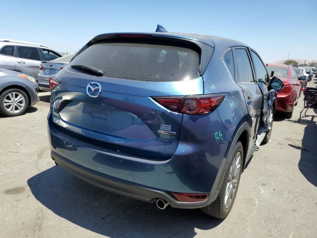 Tył i prawy bok Mazdy CX-5; widoczne wgniecenia i rysy na prawych drzwiach oraz lusterku.