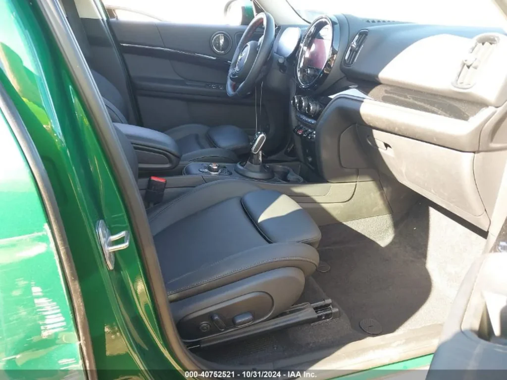 Wnętrze przodu Mini Countryman — czarne skórzane fotele, automatyczna skrzynia, kokpit.