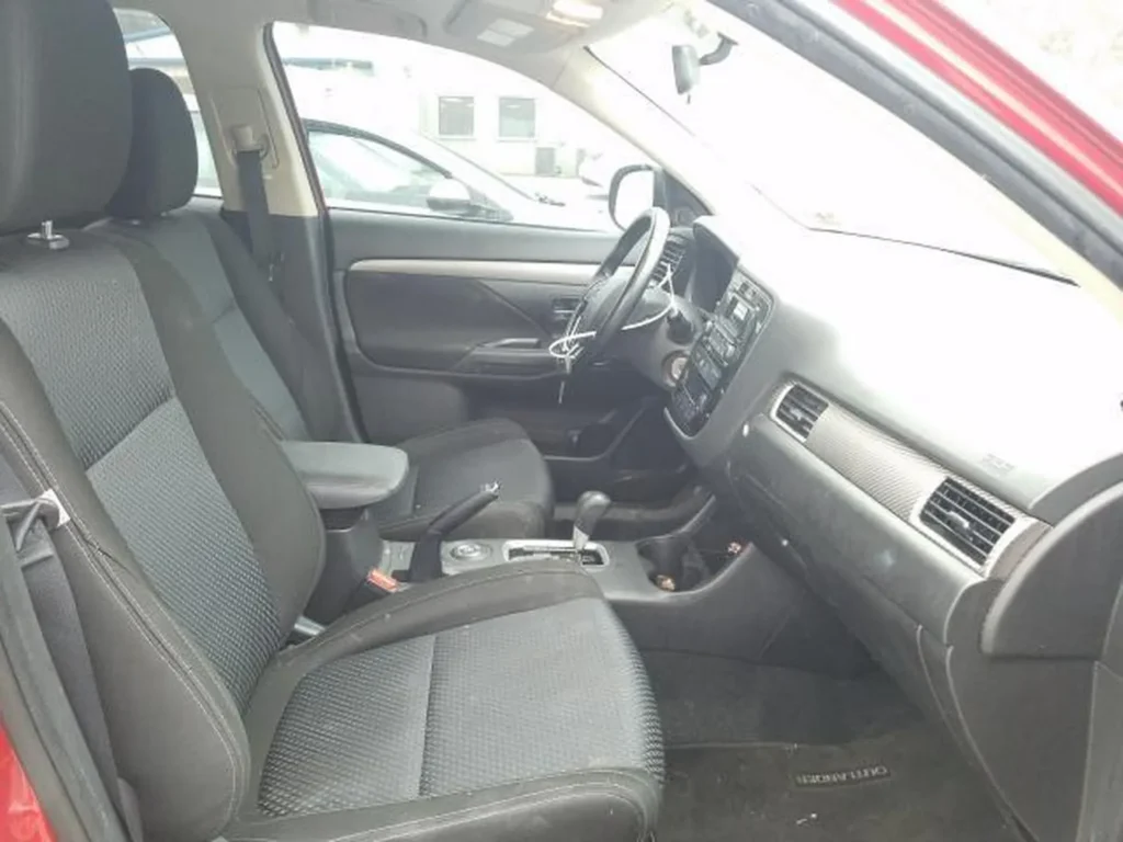 Wnętrze przodu Mitsubishi Outlandera: fotele materiałowe, kierownica, konsola środkowa.