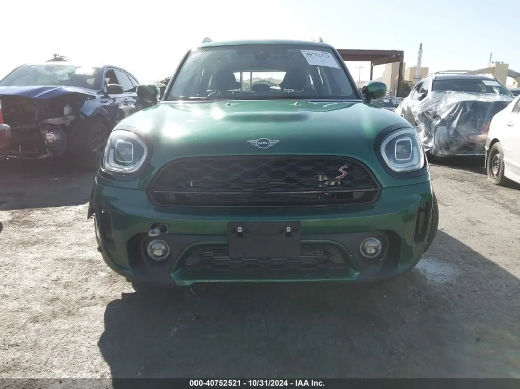 Przód zielonego Mini Countryman S; grill z emblematem „S”, brak lewej zaślepki halogenu.