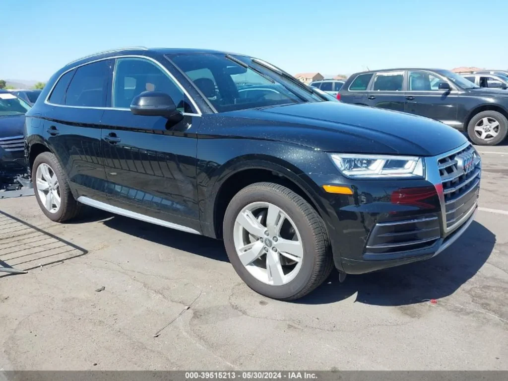 Czarny Audi Q5 z przodu z lewej strony na parkingu, lekkie zabrudzenia lakieru.