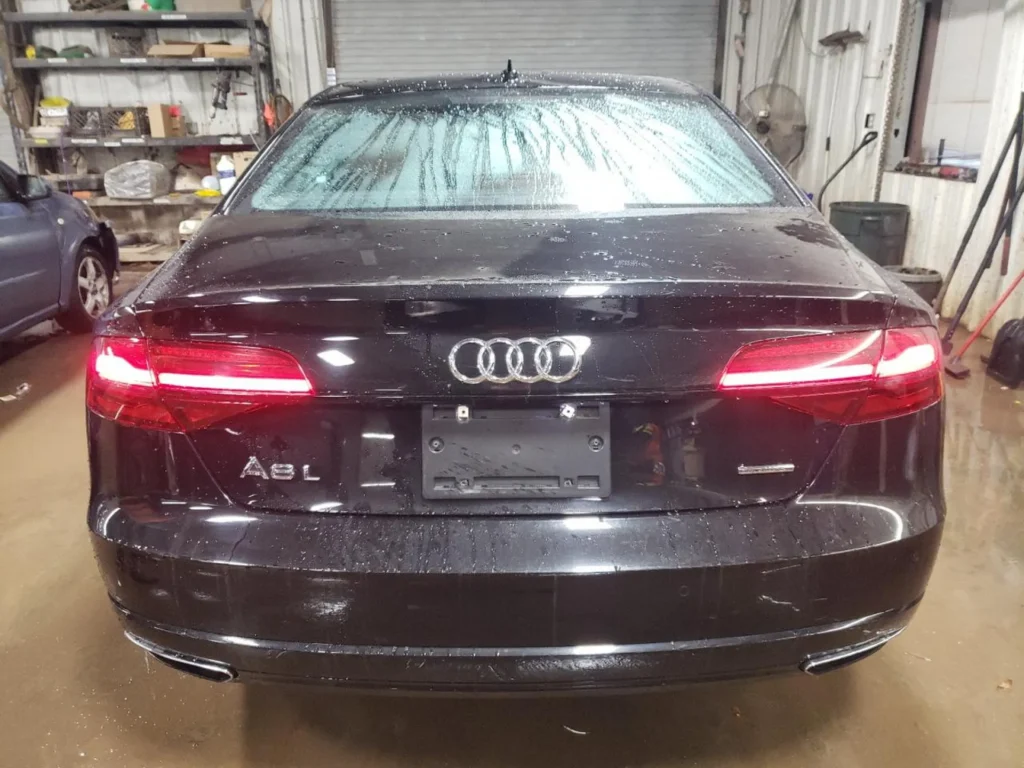 Czarny Audi A8L - widok od tyłu w hali warsztatowej.