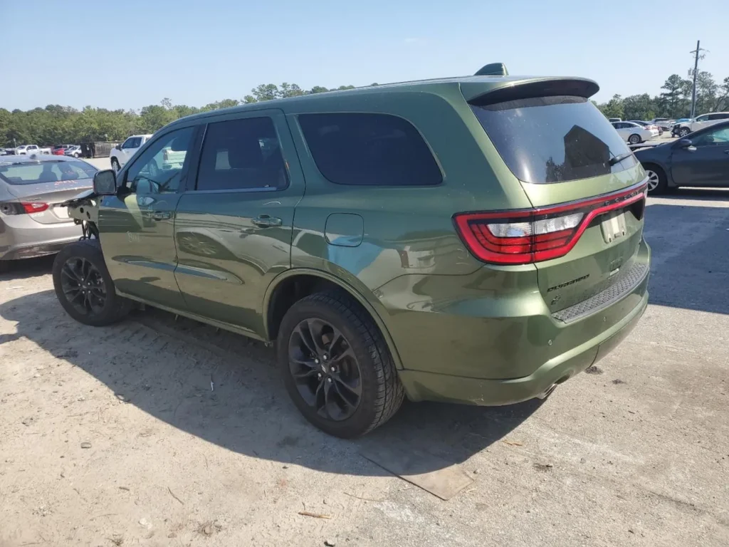 Zielony Dodge Durango z tyłu z lewej strony, zaparkowany na placu, z przyciemnianymi szybami.
