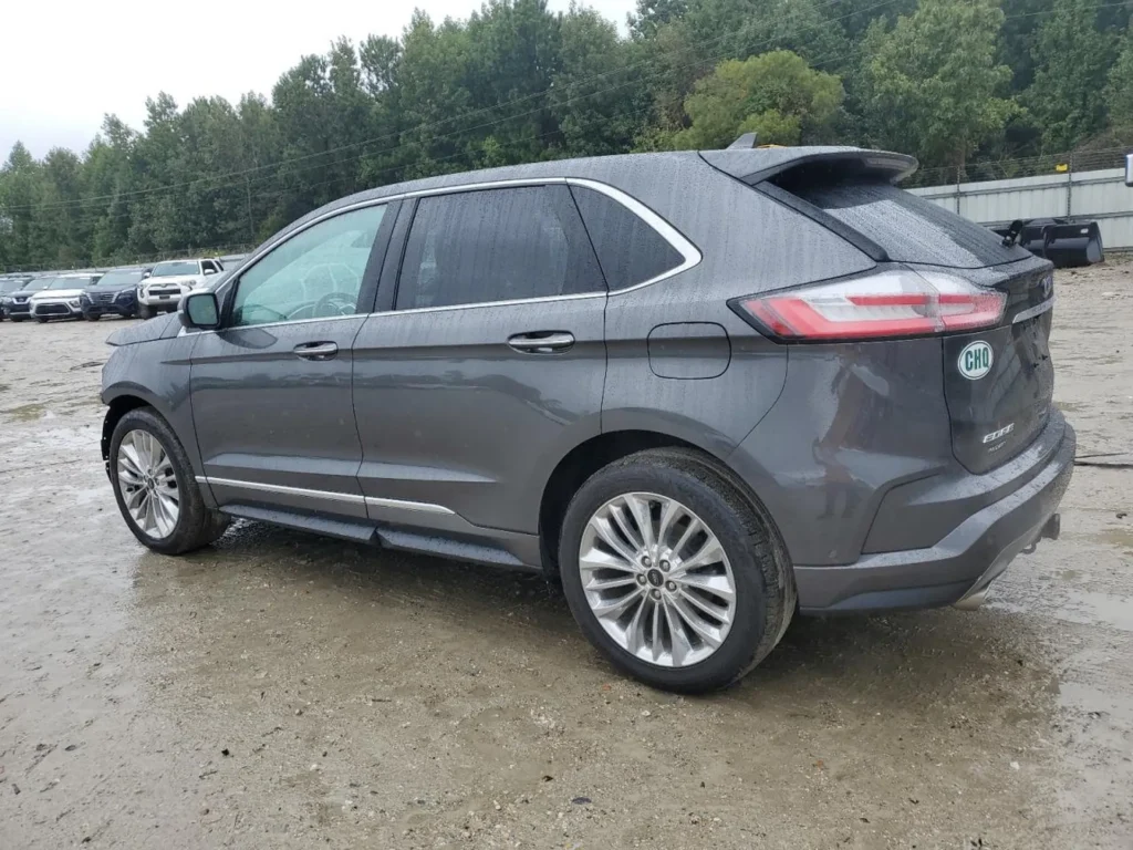 Szary Ford Edge na mokrym placu, widok z tyłu i boku