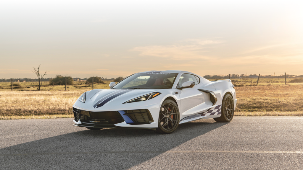 Biały Chevrolet Corvette C8 stoi na wiejskiej drodze o zachodzie słońca
