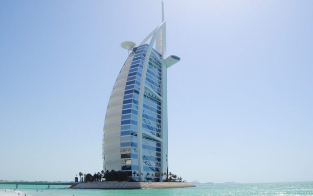 Burj Al Arab w Dubaju nad turkusowym morzem, widok z plaży w słoneczny dzień