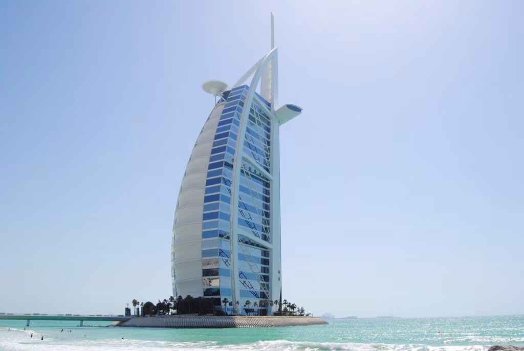 Burj Al Arab w Dubaju nad turkusowym morzem, widok z plaży w słoneczny dzień