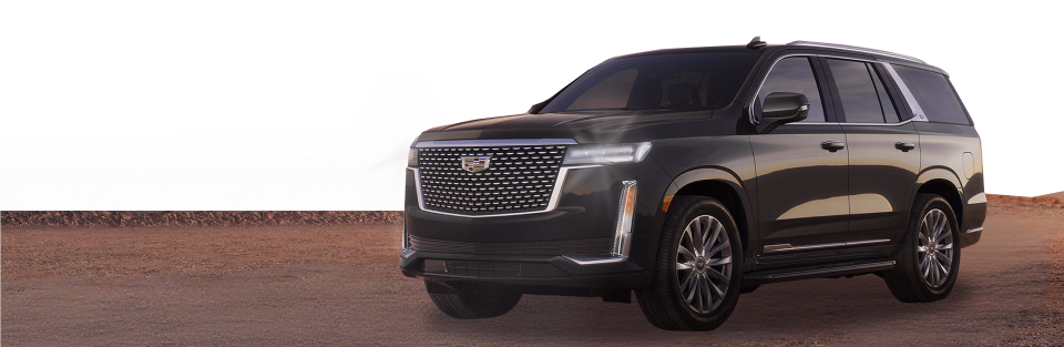 Ciemny Cadillac Escalade stoi na pustynnej drodze, w tle niskie wzgórza