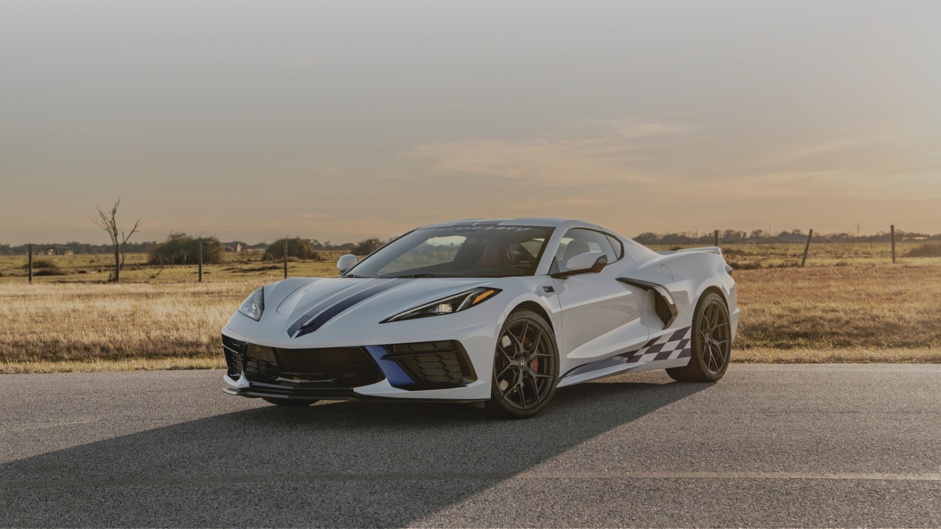 Biały Chevrolet Corvette C8 na drodze o zachodzie słońca