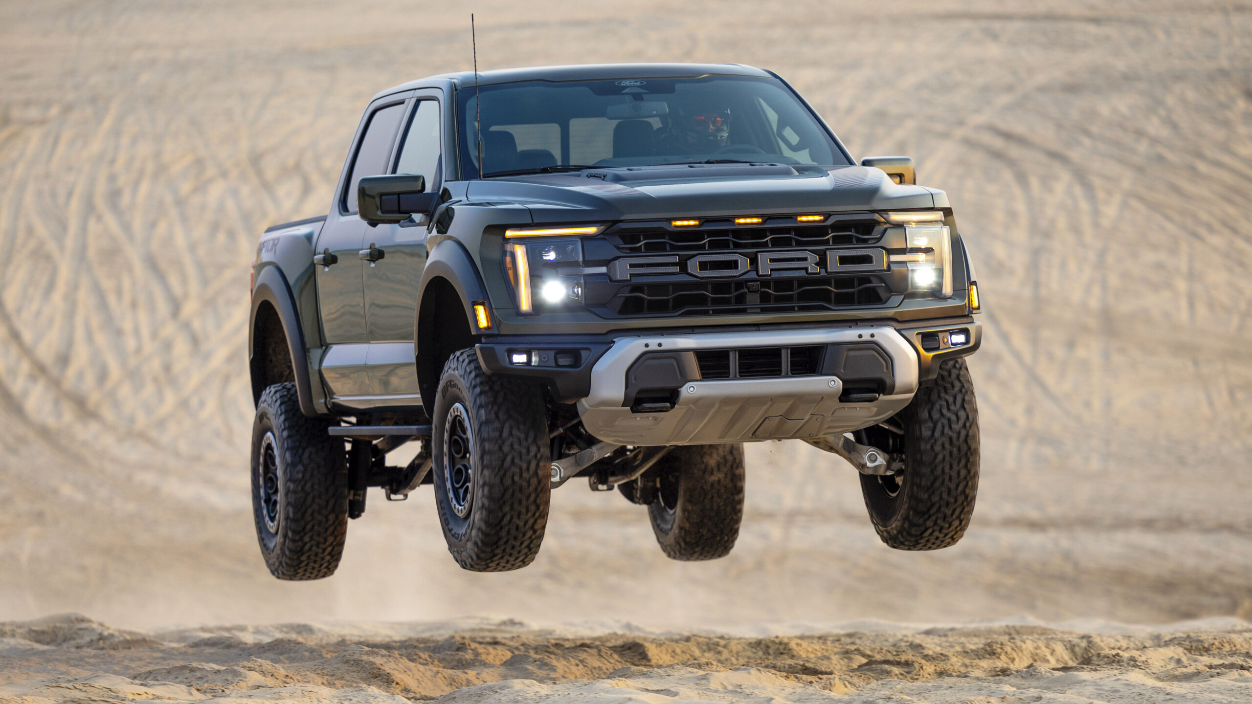 Ford Raptor skacze nad piaszczystą wydmą podczas jazdy terenowej po pustyni