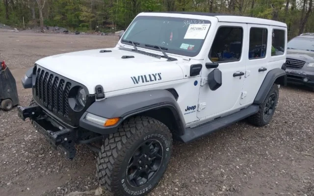 Prawy przód Jeepa Wrangler Willys 4xe; widoczna kratka grilla, poszerzone nadkola, brak zderzaka.