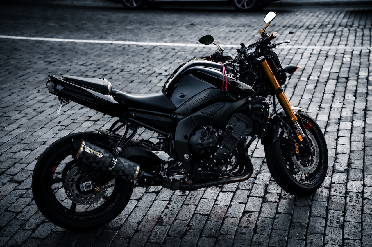 Czarny motocykl sportowy zaparkowany na brukowanej ulicy w miejskiej scenerii