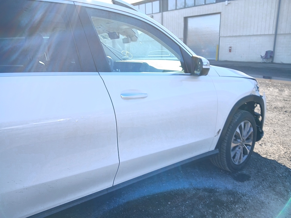 Zbliżenie na przednie drzwi i błotnik białego Mercedesa-Benz GLE