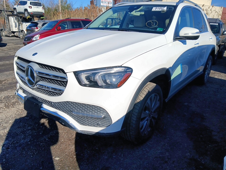 Biały Mercedes-Benz GLE zaparkowany na placu z innymi pojazdami